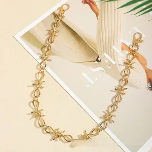 Detail of a golden barbed wire design waist chain with lobster clasps on a stylish backdrop
