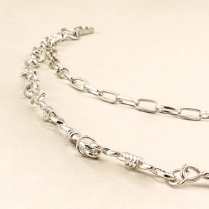 Macro detail of silver layered thorns and industrial wire chain with metallic shine