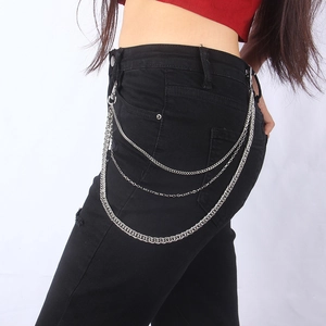Détail de la chaîne de pantalon triple couche en métal argenté sur un jean noir punk