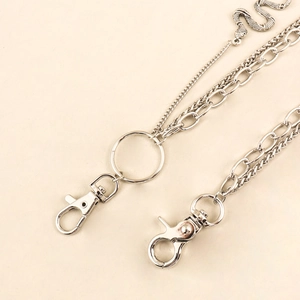 Detail of silver layered metal pant chain featuring dual chains and snake pendant charm