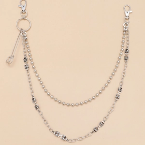 Detail view of double-layer silver punk wallet chain with skull charms and safety pin