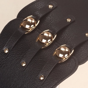 Close-up of black wide corset belt featuring gold metal buckles and rivet details