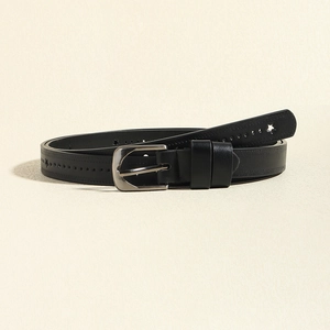 Détail d'une ceinture en cuir noir avec boucle brossée et motifs d'étoiles ajourés