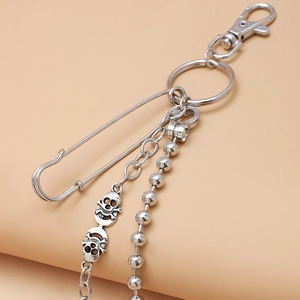 Detail of punk style double-layered metal pants chain with skull charms and safety pin