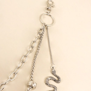 Detailed macro view of silver layered trouser chains with intricate snake pendant