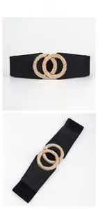 Detail of black elastic belt featuring a textured gold double ring interlocking buckle