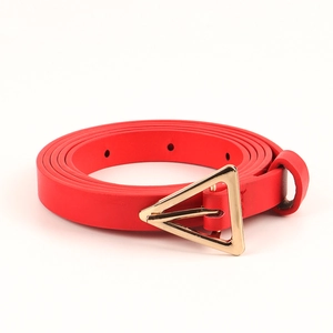 Detail of red leather belt featuring a polished gold triangle buckle and fine texture