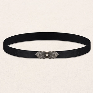 Detailed view of the vintage silver leaf buckle on a black elastic waist belt for women