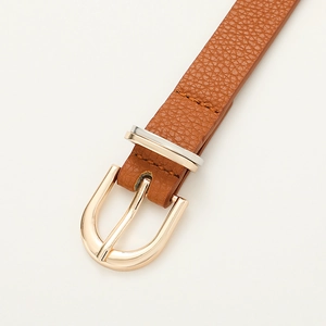 Détail de la ceinture marron caramel à grain litchi avec boucle dorée en forme de U