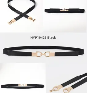 Detail of black elastic belt with golden D-ring buckle and textured leather ends