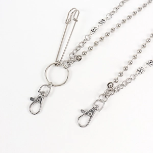 Close-up of double-layered punk pants chain with silver skull beads and safety pin detail