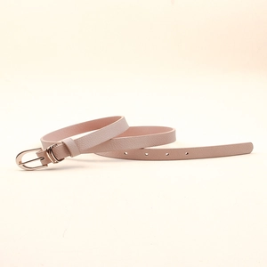Détail d'une ceinture en cuir grainé rose avec une boucle ronde dorée sur fond neutre