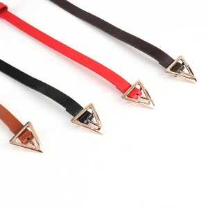 Detail view of thin leather belts with gold triangular buckles in four classic colors
