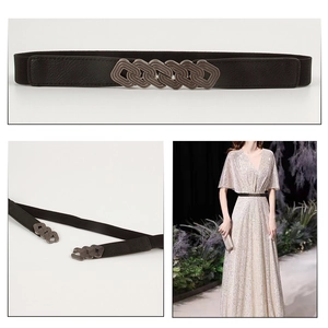 Detail of vintage bronze geometric buckle and elastic black waist belt for dresses