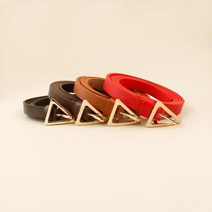 Detail of minimalist skinny belts with polished gold triangle buckles in four versatile colors
