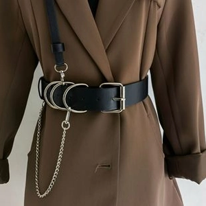 Close-up of black PU leather belt with silver metal rings and hanging chain accessory