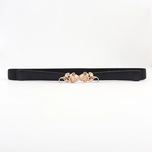 Détail de la boucle de rose dorée élégante sur une ceinture élastique noire pour femme