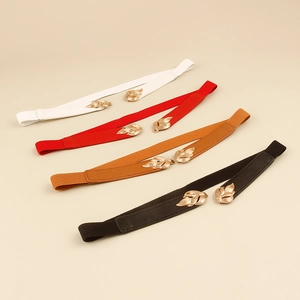 Detail of four colorful elastic belts featuring elegant gold leaf buckles for dresses