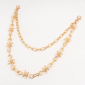 Detail van dubbellaagse gouden metalen broekketting met punkstijl doornontwerp
