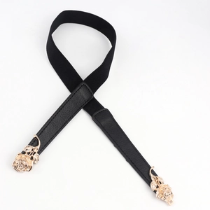 Détail de boucles de roses dorées sur une ceinture élastique noire élégante pour femme