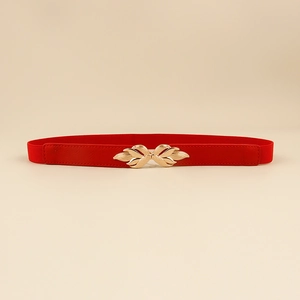 Detail of red elastic waist belt featuring a gold leaf-shaped metal buckle for dresses