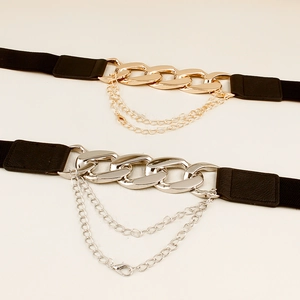 Dettaglio della cintura elastica con fibbia in metallo e catenelle decorative a strati
