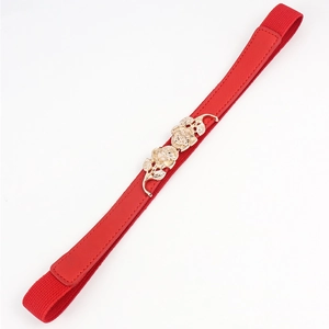 Détail de la boucle en métal rose doré sur une ceinture élastique rouge pour robe