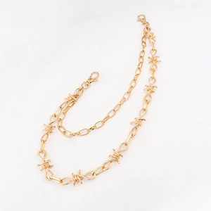 Detail van de gouden punk broekketting met dubbele lagen, doornen en karabijnhaak