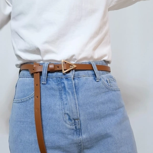 Brown leather belt with golden triangle buckle shown on light blue denim jeans