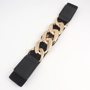 Dettaglio di una cintura elastica nera con grande fibbia a catena dorata decorativa