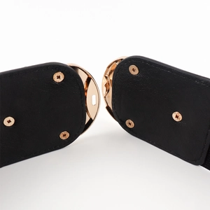 Close-up of black elastic waist belt with gold buckle and screw reinforcement detail