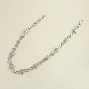 Detail van zilveren metalen prikkeldraad dubbele ketting met karabijnsluitingen voor broek