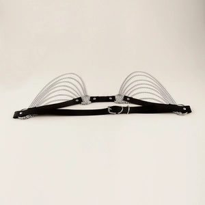 Detail of punk body harness featuring black webbing and multiple silver metal chains