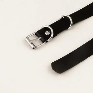 Detail of black punk leather belt with silver square buckle and double D-ring hardware