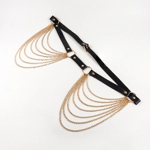 Close-up of black leather leg strap with multilayer gold chains in punk style