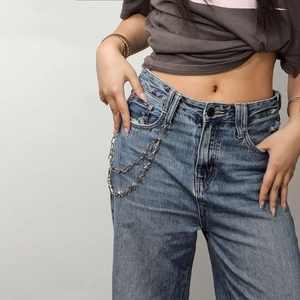 Detailweergave van dubbellaagse punk metalen broekketting met stekels op een lichtblauwe jeans
