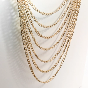 Multi-layered gold chain necklace with chunky metallic links and bold punk aesthetic