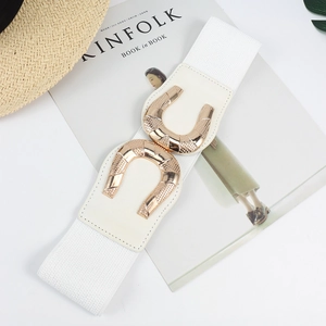 Detail of white elastic waist belt featuring golden horseshoe double buckles on a magazine