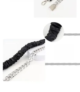 Detail of elastic black PU leather belt with chunky silver chain and metal lock buckle