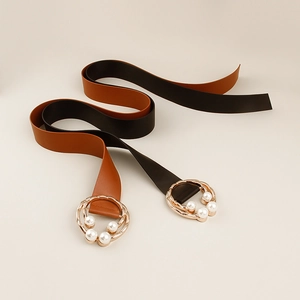 Close-up of elegant wide belts with gold buckles and pearl bow details for dresses