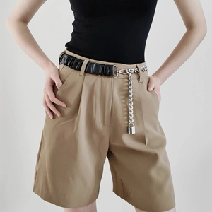 Close-up of khaki high-waist shorts with black PU leather and silver chain lock belt