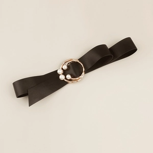 Detail of elegant black satin waist belt featuring gold buckle with pearl embellishments