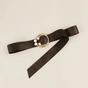 Close-up of gold double-ring buckle with white pearls on a black leather belt