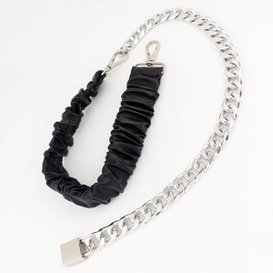 Close-up of metallic chain belt with black PU leather strap and silver lobster clasp