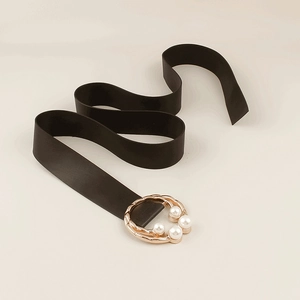 Detail of elegant black waist belt featuring gold twisted buckle with four pearls