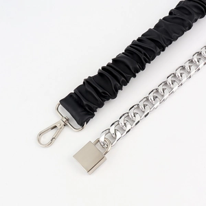 Detail of black pleated PU strap with silver metal chain and lock pendant clasp