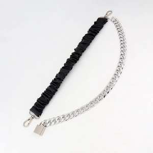 Detail of metal padlock and chain stitching on black PU elastic belt for women