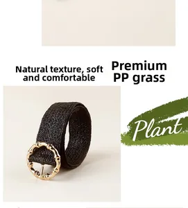 Detail of black woven straw belt featuring a gold round buckle with bamboo texture