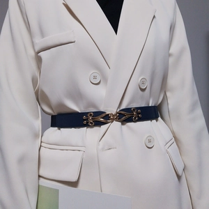 Ceinture élastique femme bleu foncé avec boucle dorée vintage sur costume blanc