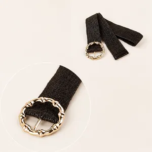 Detail of black woven elastic belt with golden bamboo texture round buckle for dresses